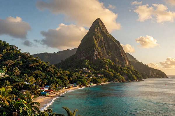 The iconic Pitons twin volcanic peaks rising from the turquoise Caribbean sea in Saint Lucia at sunset