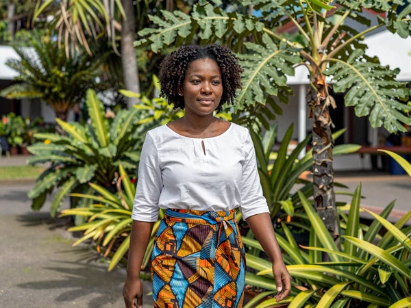 Vincentian woman walking through the historic Botanical Gardens in Kingstown surrounded by tropical plants