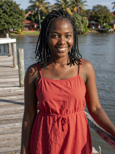 Keandra, 25, a cheerful Afro-Guyanese woman at the Berbice River pier in New Amsterdam